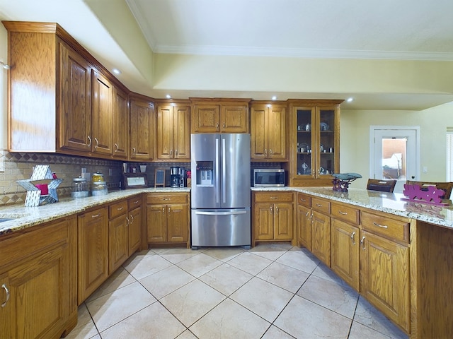 kitchen featuring ornamental molding, backsplash, appliances with stainless steel finishes, and light stone countertops