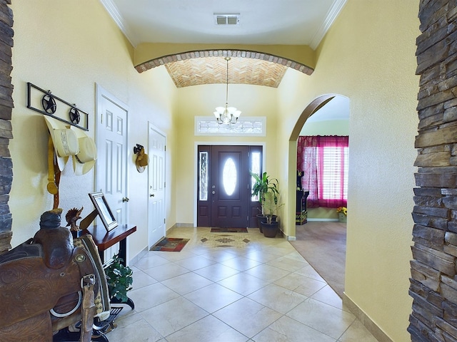 foyer featuring a high ceiling, crown molding, a chandelier, and light tile patterned floors