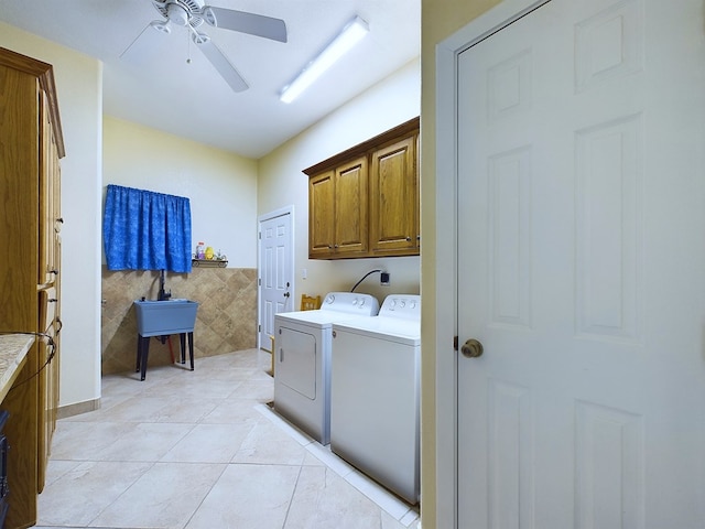 laundry area with cabinets, tile walls, ceiling fan, separate washer and dryer, and light tile patterned flooring