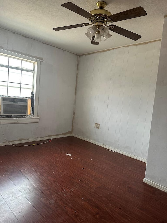 spare room featuring dark hardwood / wood-style flooring, cooling unit, a textured ceiling, and ceiling fan