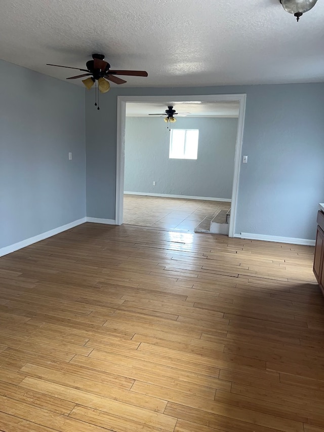 unfurnished room featuring light hardwood / wood-style floors and a textured ceiling