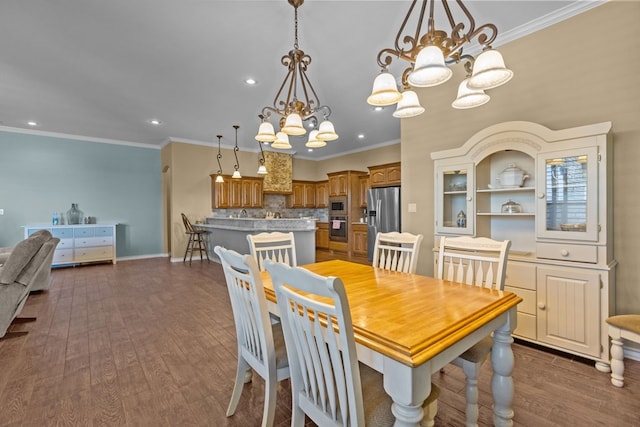 dining space featuring baseboards, crown molding, an inviting chandelier, and dark wood-style flooring