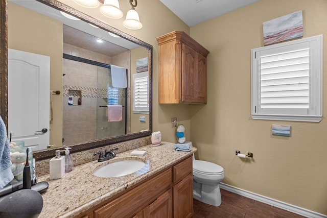 full bath with a shower stall, baseboards, toilet, wood finished floors, and vanity