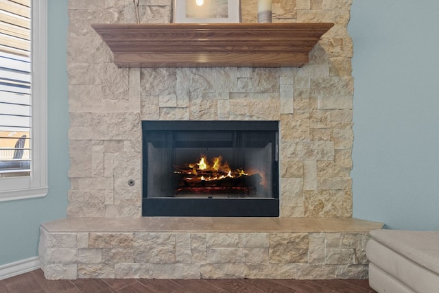 details featuring wood finished floors and a lit fireplace