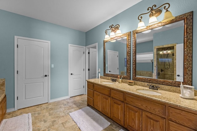 full bath featuring a tile shower, stone finish floor, double vanity, and a sink