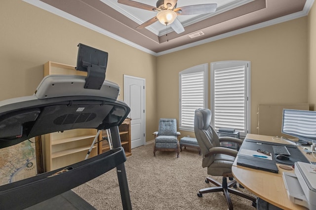 office area with visible vents, ceiling fan, carpet, ornamental molding, and a raised ceiling