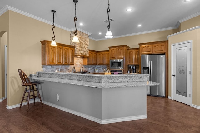 kitchen with visible vents, arched walkways, appliances with stainless steel finishes, a peninsula, and brown cabinetry