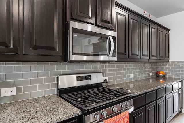 kitchen with stone counters, stainless steel appliances, and backsplash