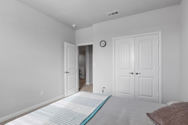 bedroom featuring a closet, visible vents, baseboards, and carpet flooring