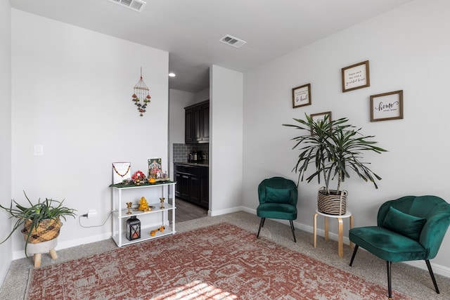 sitting room featuring carpet flooring, visible vents, and baseboards