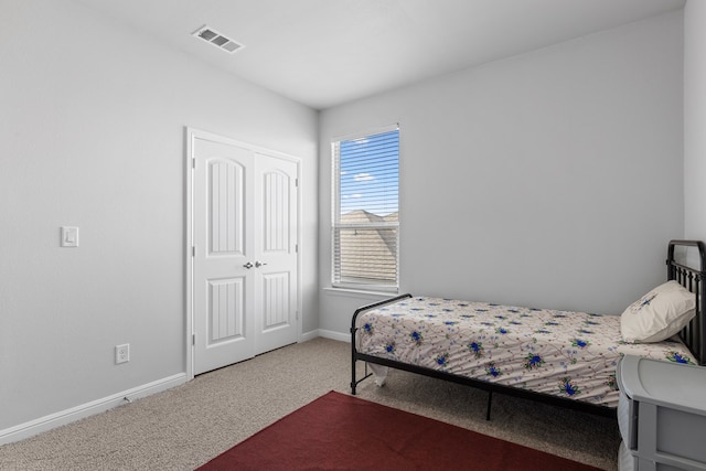 bedroom featuring a closet, carpet, visible vents, and baseboards