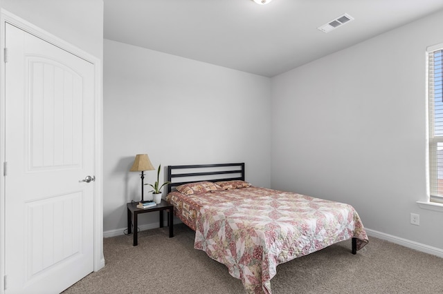 carpeted bedroom featuring visible vents and baseboards