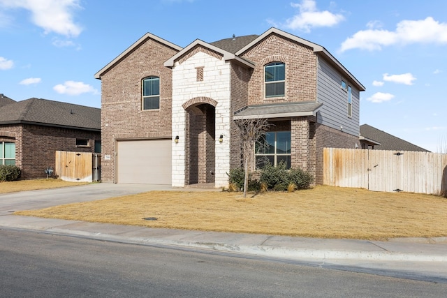 view of front of house with brick siding, fence, and an attached garage