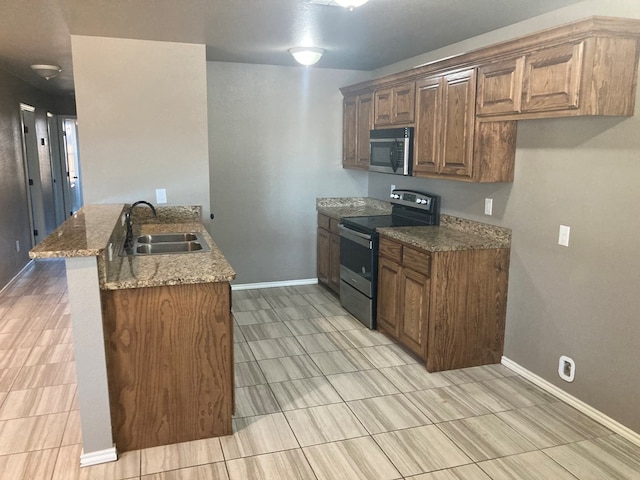 kitchen with kitchen peninsula, a breakfast bar, sink, stone counters, and black range with electric stovetop