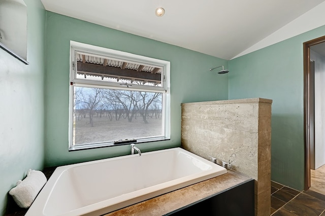 bathroom with a tub to relax in, tile patterned floors, and lofted ceiling