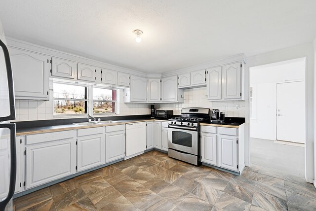 kitchen featuring white dishwasher, white cabinetry, and stainless steel range with gas stovetop