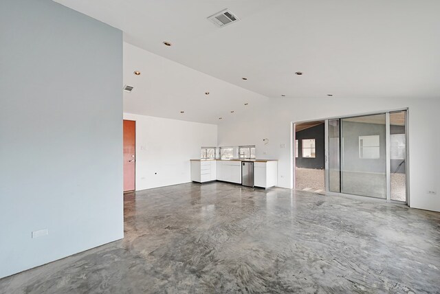 unfurnished living room featuring concrete flooring and lofted ceiling