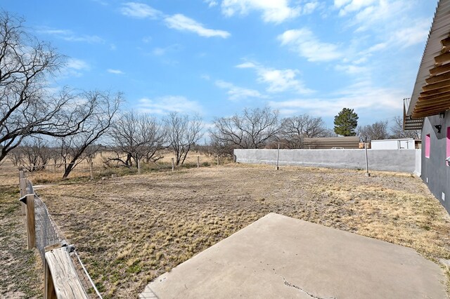 view of yard with a rural view and a patio area