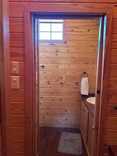 bathroom featuring wooden walls and vanity