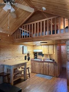 kitchen with ceiling fan, wooden walls, wood-type flooring, wooden ceiling, and lofted ceiling