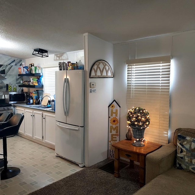 kitchen with white cabinets, sink, appliances with stainless steel finishes, and a textured ceiling