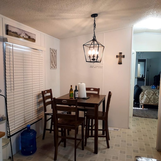 dining space with a notable chandelier and a textured ceiling