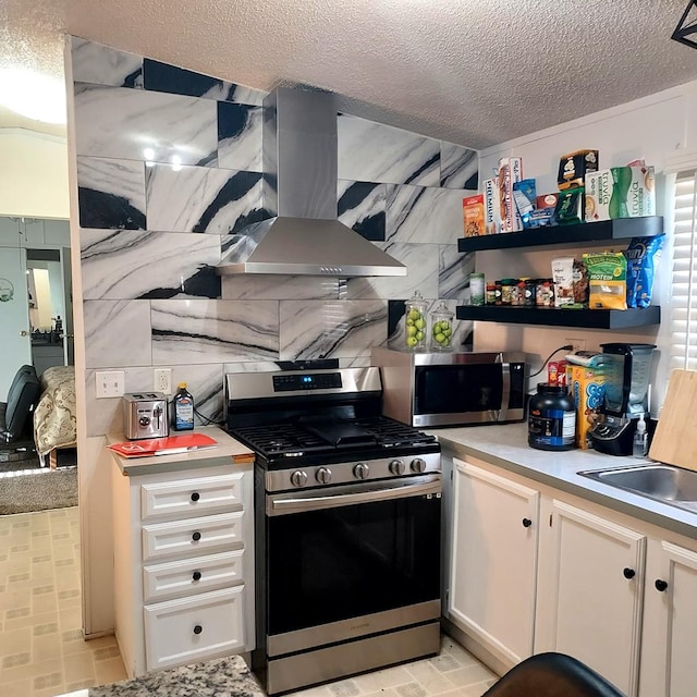 kitchen featuring sink, stainless steel appliances, a textured ceiling, white cabinets, and exhaust hood