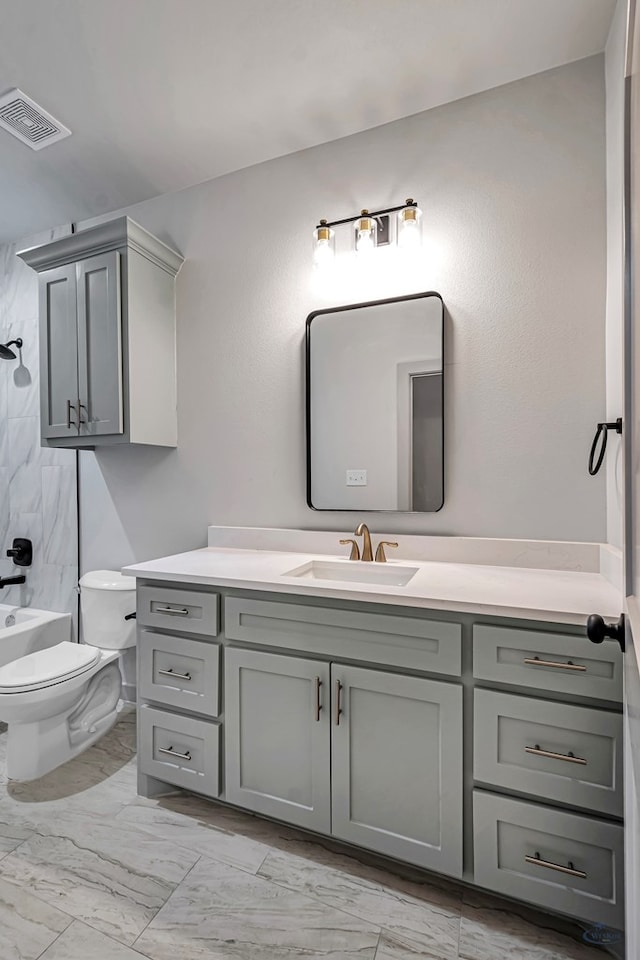 full bathroom featuring vanity, tiled shower / bath combo, and toilet