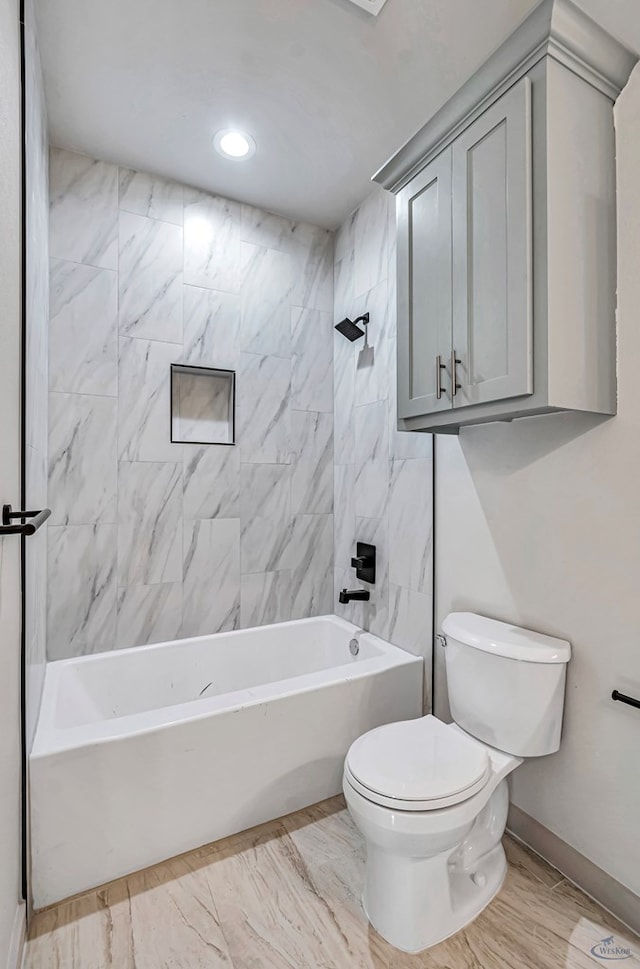 bathroom with toilet and tiled shower / bath