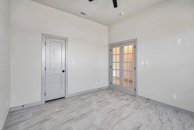 spare room with ceiling fan and french doors