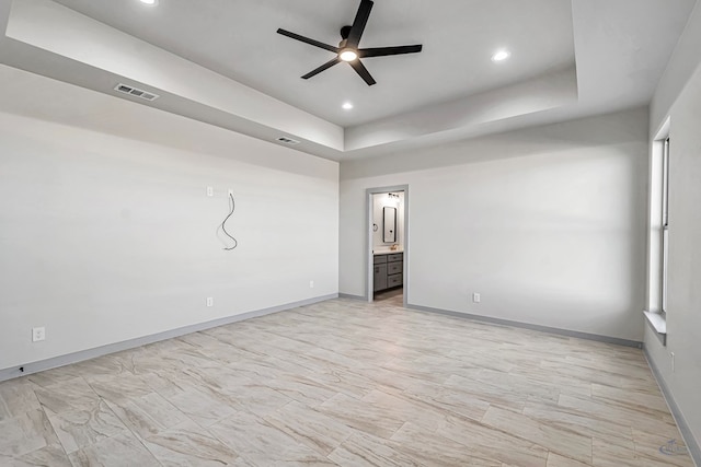 unfurnished room featuring a tray ceiling and ceiling fan