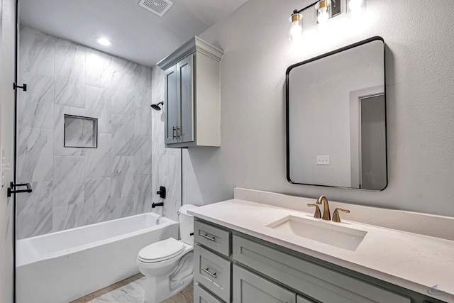 full bathroom with vanity, tiled shower / bath combo, and toilet