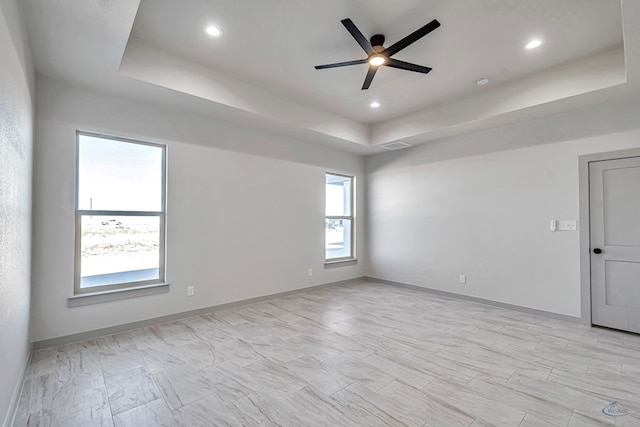 unfurnished room with a raised ceiling and ceiling fan