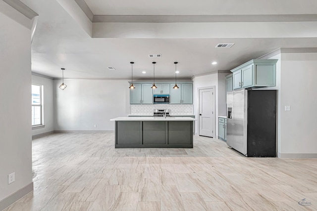 kitchen featuring stove, backsplash, stainless steel fridge with ice dispenser, hanging light fixtures, and an island with sink