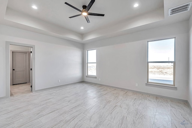 unfurnished room featuring ceiling fan and a tray ceiling