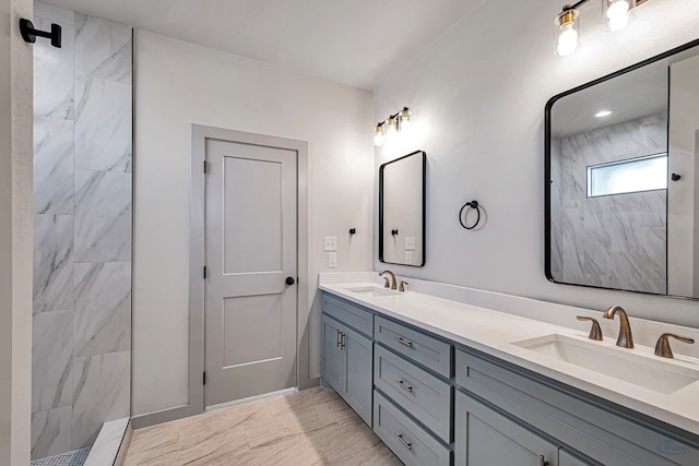 bathroom with a tile shower and vanity