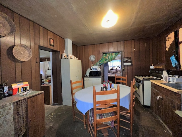 dining space with washing machine and dryer and wooden walls