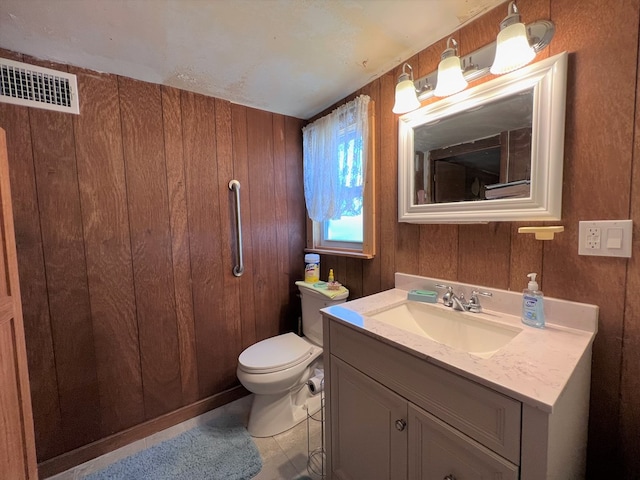 bathroom with tile patterned floors, wood walls, vanity, and toilet