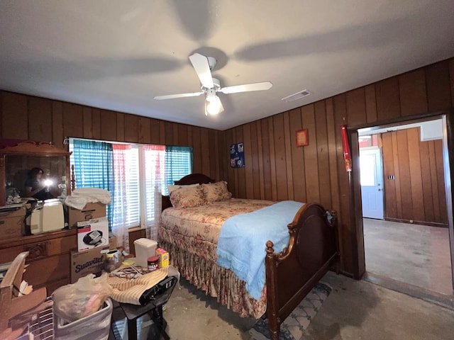 bedroom featuring ceiling fan and wooden walls