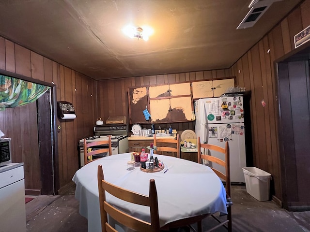 kitchen with wood walls and white refrigerator