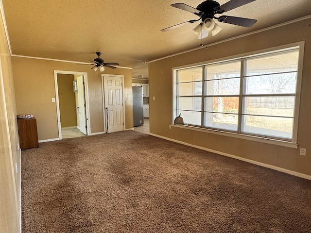 empty room featuring carpet, crown molding, ceiling fan, a textured ceiling, and baseboards