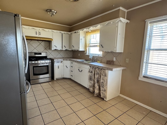 kitchen with appliances with stainless steel finishes, light tile patterned flooring, ornamental molding, and under cabinet range hood