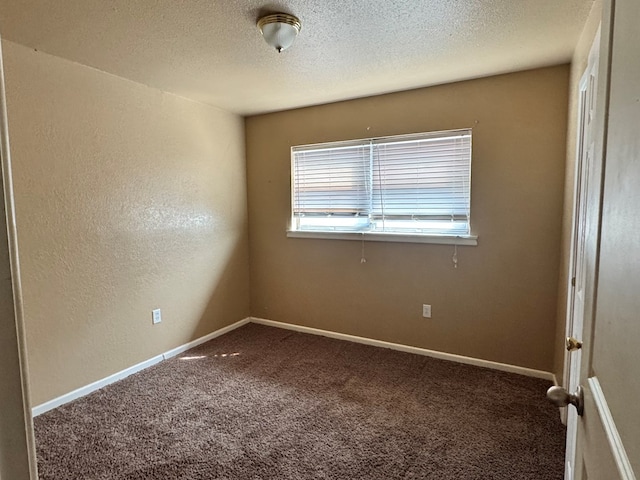 carpeted spare room with a textured wall, a textured ceiling, and baseboards