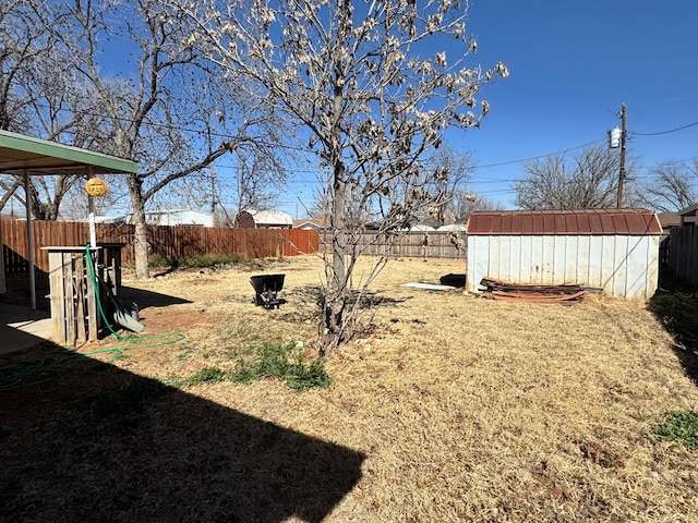 view of yard with a fenced backyard, an outdoor structure, and a shed