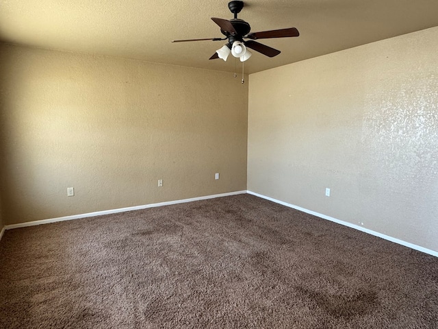 unfurnished room with a ceiling fan, a textured wall, dark carpet, and baseboards