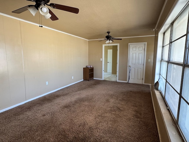 carpeted empty room with a textured ceiling, ornamental molding, a ceiling fan, and baseboards