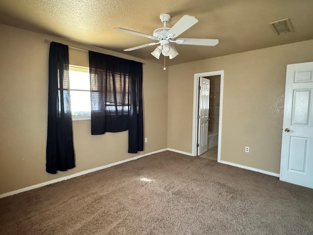 carpeted spare room with baseboards, ceiling fan, visible vents, and a textured ceiling