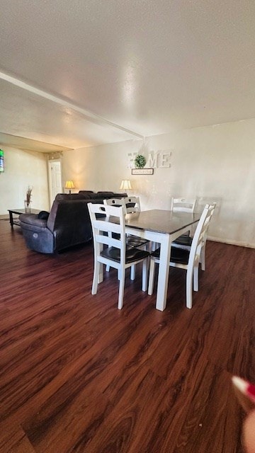 dining room featuring dark wood-type flooring and a textured ceiling