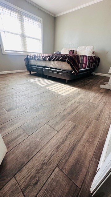 bedroom featuring crown molding and hardwood / wood-style flooring