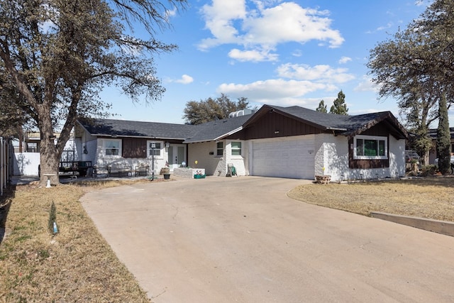 single story home with a garage, driveway, and brick siding